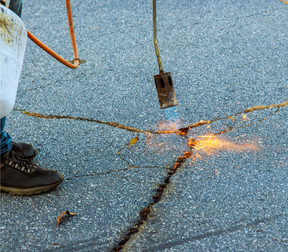 Asphalt crack being sealed with heat