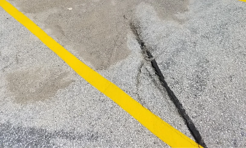 Yellow parking line on cracked asphalt