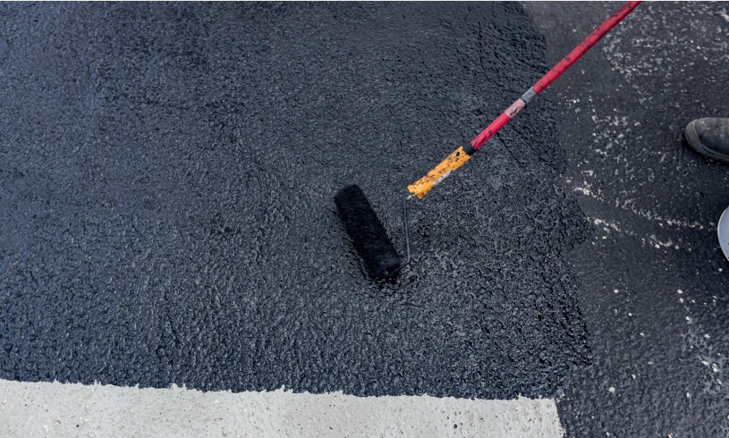 Painting asphalt with roller brush